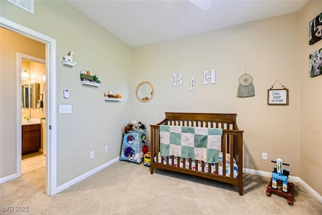 bedroom with light carpet, baseboards, and a nursery area
