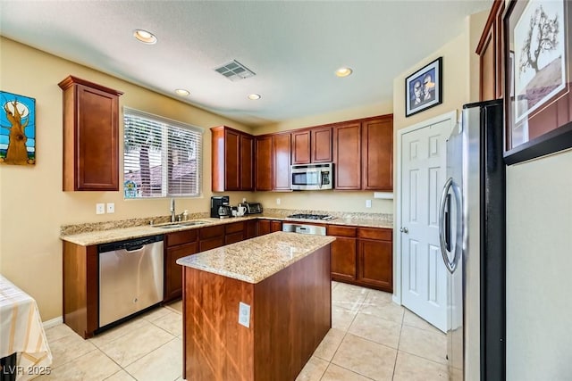 kitchen featuring appliances with stainless steel finishes, visible vents, light tile patterned floors, and a sink