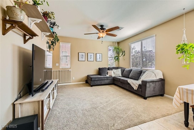 tiled living area featuring carpet flooring, baseboards, a ceiling fan, and visible vents