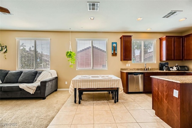 kitchen with a sink, a healthy amount of sunlight, open floor plan, and stainless steel dishwasher