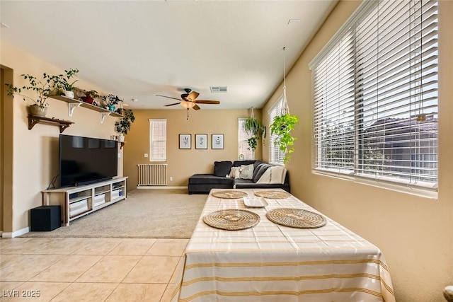 carpeted living area featuring visible vents, tile patterned flooring, baseboards, and ceiling fan