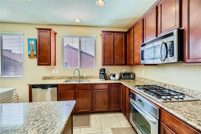 kitchen featuring a sink, recessed lighting, light tile patterned floors, light stone countertops, and appliances with stainless steel finishes