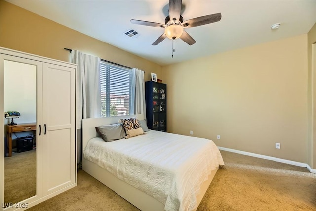 bedroom with baseboards, a ceiling fan, visible vents, and light colored carpet