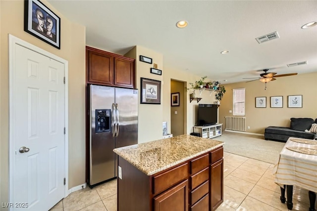 kitchen featuring a ceiling fan, light colored carpet, stainless steel refrigerator with ice dispenser, and visible vents