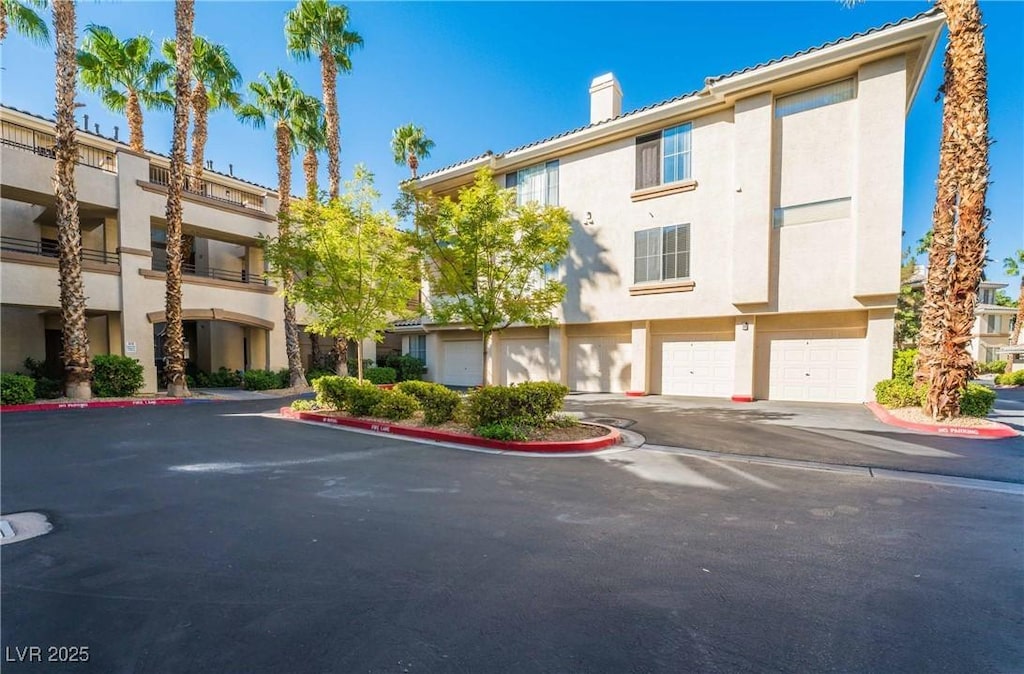 7189 S Durango Dr Unit 203, Las Vegas, NV 89113 - view of property featuring a garage and driveway