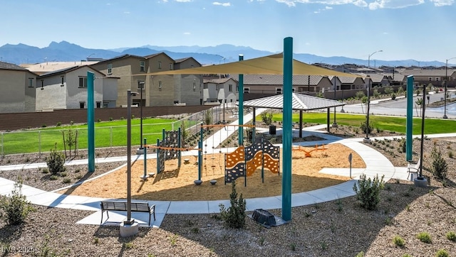 communal playground featuring a gazebo, fence, a mountain view, and a residential view