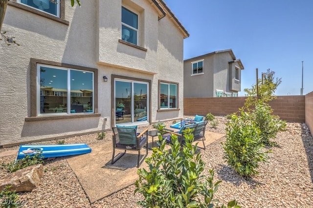 back of house with an outdoor hangout area, a patio area, stucco siding, and fence