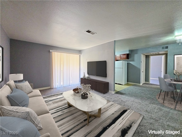 carpeted living area with a textured ceiling, visible vents, and baseboards