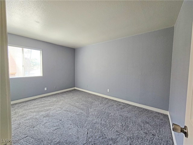 spare room featuring a textured ceiling, carpet floors, and baseboards