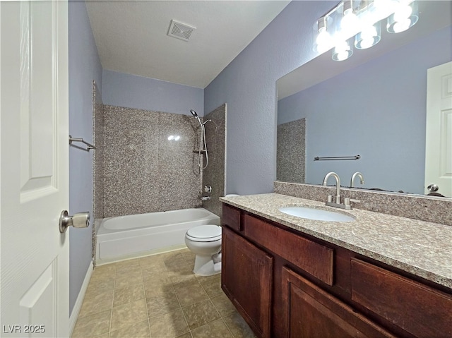 bathroom featuring toilet, vanity, visible vents, tile patterned floors, and bathtub / shower combination