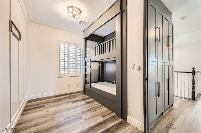unfurnished bedroom featuring light wood-style flooring, baseboards, and visible vents