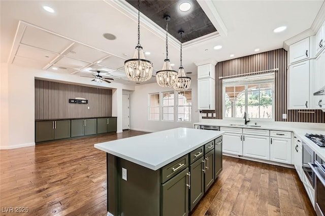 kitchen featuring a sink, hardwood / wood-style flooring, ceiling fan with notable chandelier, and white cabinets