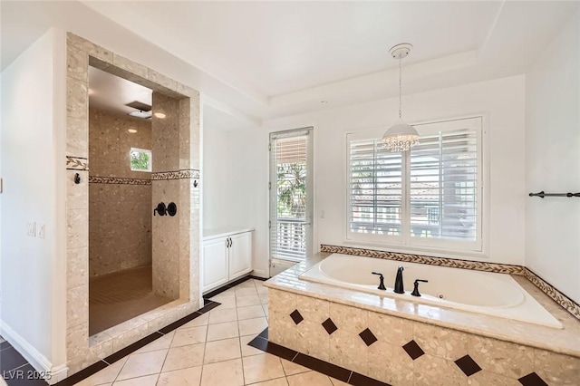 bathroom with an inviting chandelier, a tile shower, tile patterned floors, a bath, and a raised ceiling