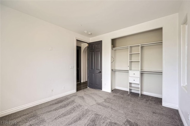 unfurnished bedroom with carpet, baseboards, and a closet