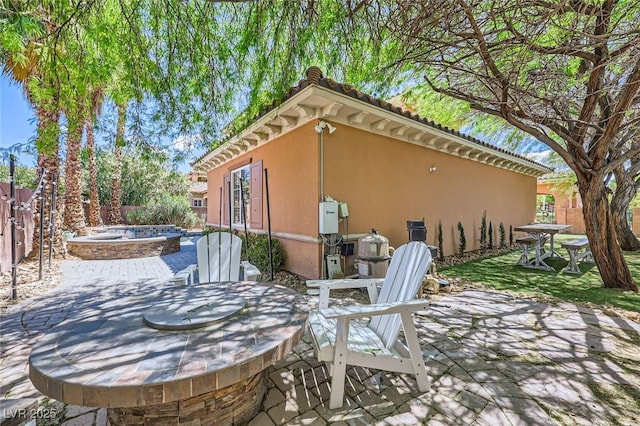view of patio featuring an outdoor hot tub and a fenced backyard