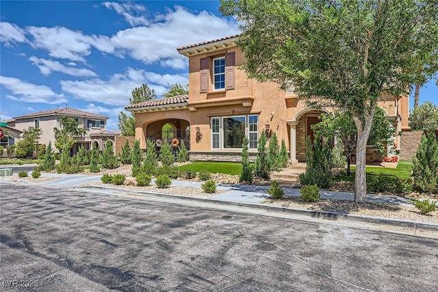 mediterranean / spanish-style home with stucco siding and a tile roof