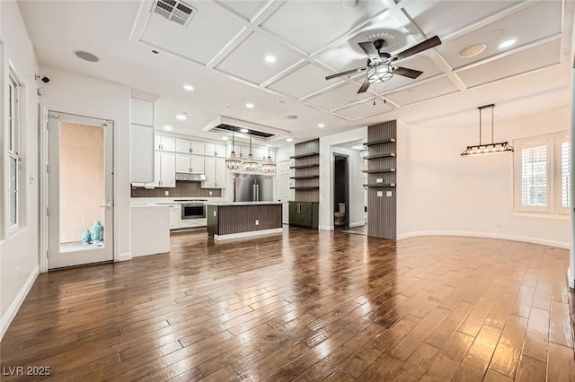 unfurnished living room with coffered ceiling, dark wood finished floors, visible vents, and a ceiling fan