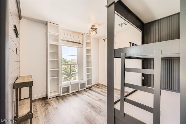 unfurnished bedroom with baseboards, visible vents, and wood finished floors