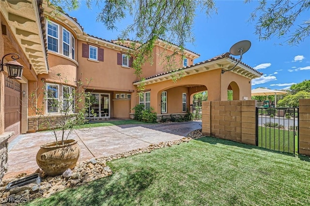 rear view of property featuring fence, stucco siding, and a lawn
