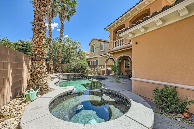 view of pool with a fenced backyard, a patio, and a pool with connected hot tub