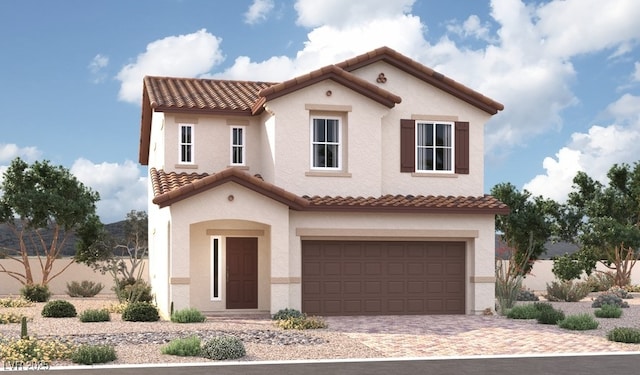 mediterranean / spanish home with stucco siding, a tiled roof, and a garage