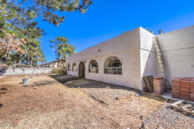 rear view of property with fence and stucco siding