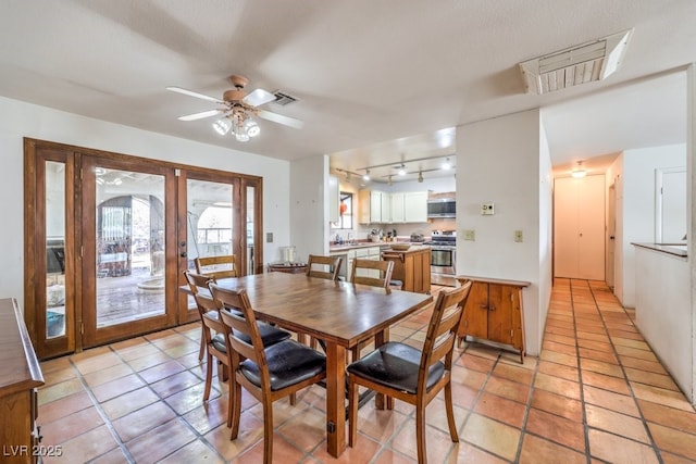 dining area featuring rail lighting, french doors, ceiling fan, and light tile patterned floors
