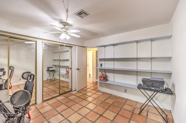 interior space with visible vents and a ceiling fan