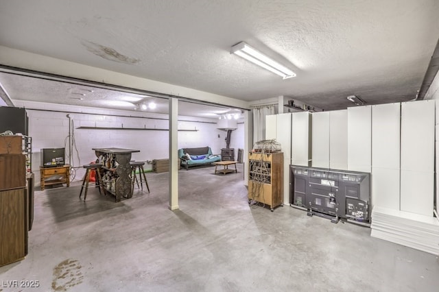 finished basement featuring a textured ceiling and concrete block wall