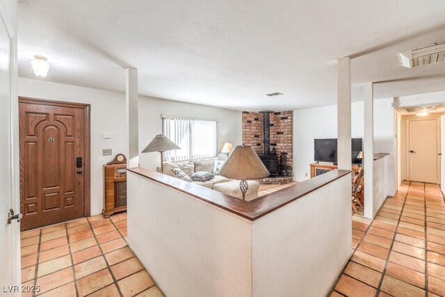 living area featuring a wood stove and visible vents