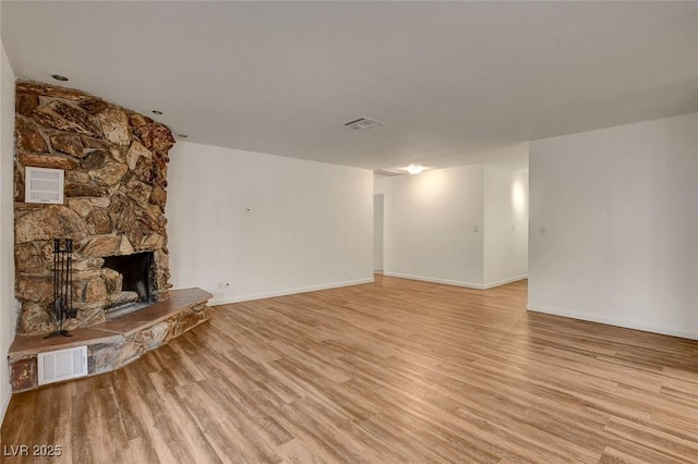 unfurnished living room with light wood-style floors, visible vents, baseboards, and a fireplace