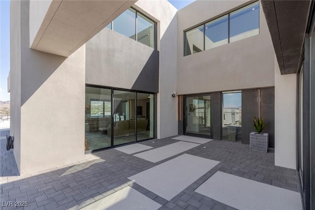 rear view of property featuring stucco siding and a patio area