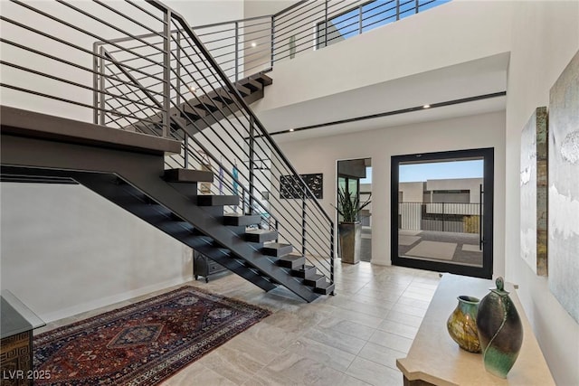interior space with stairway and a towering ceiling