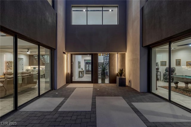 view of exterior entry with ceiling fan, a patio, and stucco siding