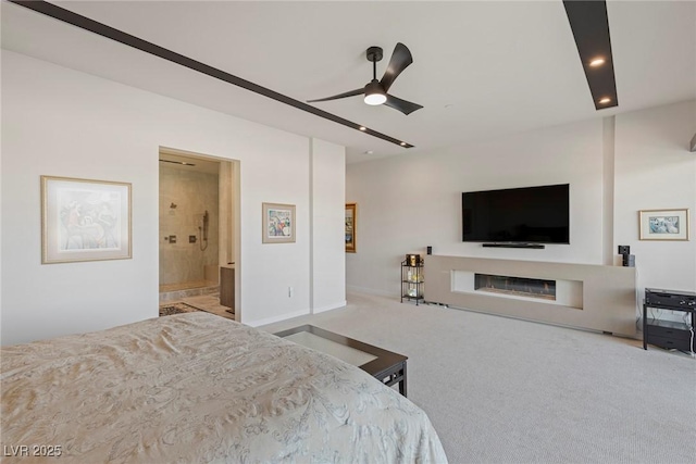 carpeted bedroom featuring a glass covered fireplace, connected bathroom, recessed lighting, and a ceiling fan