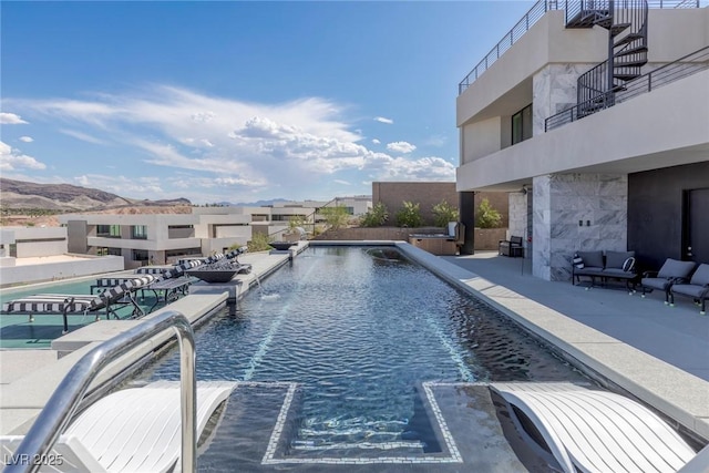 outdoor pool with an outdoor hangout area and a patio