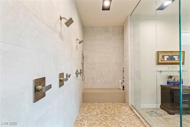 bathroom featuring a tile shower and vanity