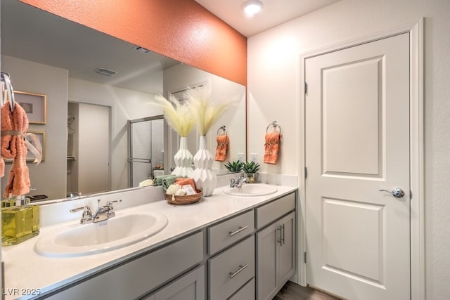 bathroom featuring a sink, double vanity, and an enclosed shower