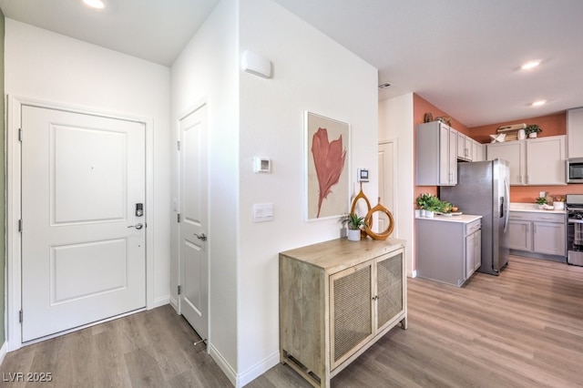 kitchen featuring light wood-style flooring, light countertops, recessed lighting, and appliances with stainless steel finishes