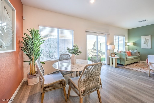 dining space featuring baseboards, visible vents, and wood finished floors
