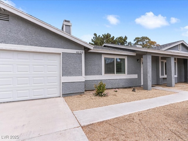 ranch-style home with stucco siding, a garage, and a chimney