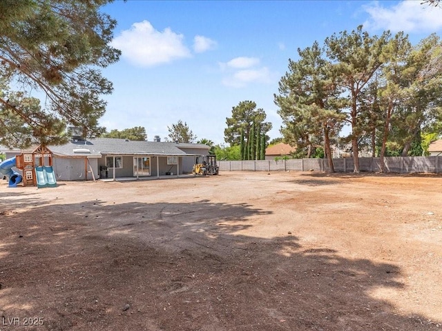 view of yard featuring fence and a playground