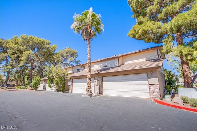 3249 Dayflower St Unit C, Las Vegas, NV 89121 - view of front of house with stone siding, a garage, and driveway