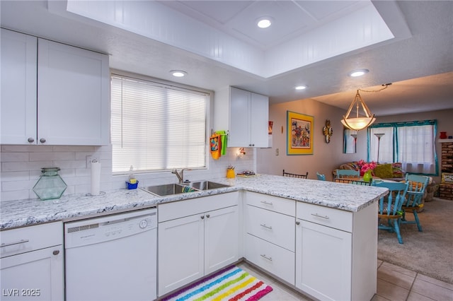 3249 Dayflower St Unit C, Las Vegas, NV 89121 - kitchen featuring dishwasher, a sink, a peninsula, a raised ceiling, and white cabinets
