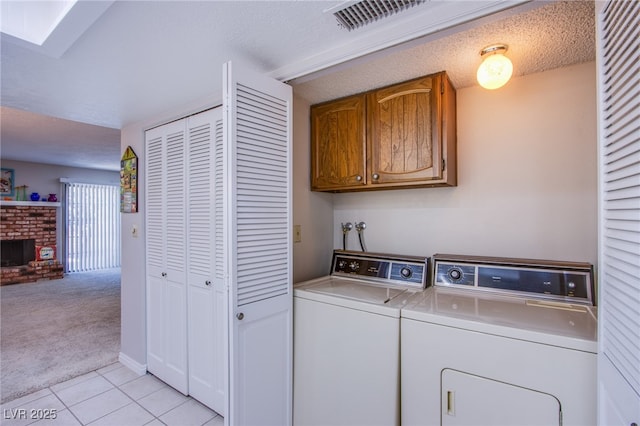 3249 Dayflower St Unit C, Las Vegas, NV 89121 - laundry area with light tile patterned floors, cabinet space, washer and clothes dryer, visible vents, and light carpet