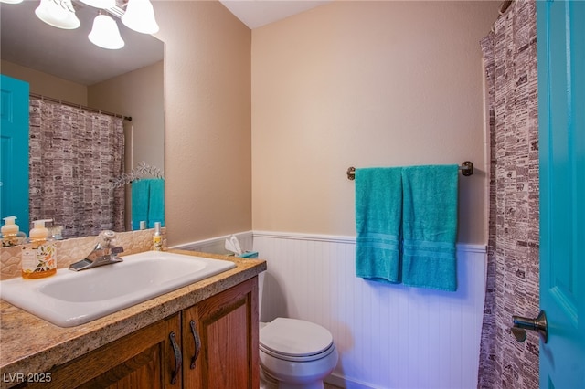 3249 Dayflower St Unit C, Las Vegas, NV 89121 - bathroom with toilet, vanity, and a wainscoted wall
