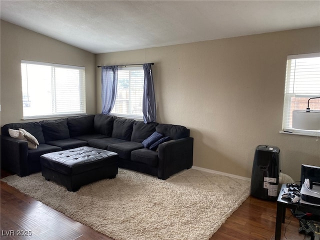 living area with dark wood-type flooring, baseboards, and lofted ceiling