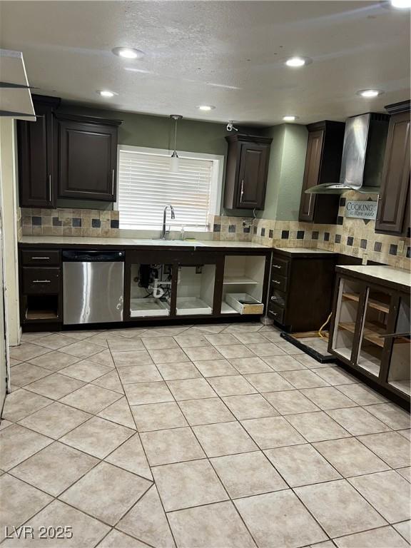 kitchen featuring backsplash, wall chimney range hood, a sink, and dishwasher