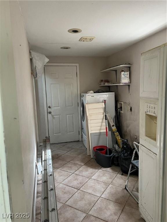 clothes washing area featuring laundry area, light tile patterned flooring, and independent washer and dryer
