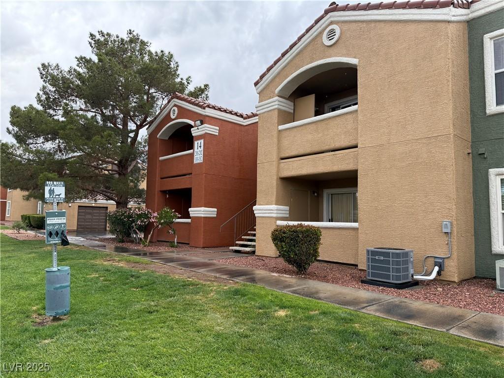 view of building exterior with cooling unit and a detached garage
